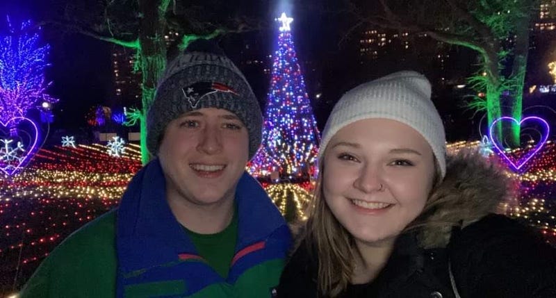 A man and woman in front of neon lights