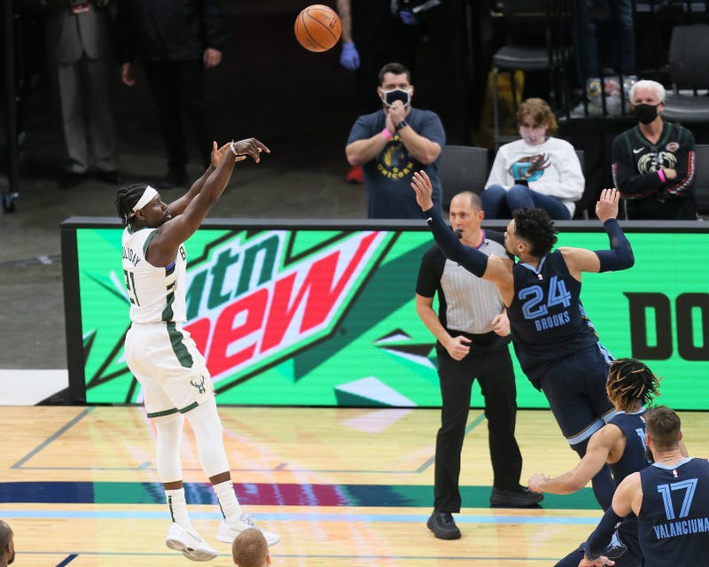 Mar 4, 2021; Memphis, Tennessee, USA; Milwaukee Bucks guard Jrue Holiday (21) shoots a game winning shot in the fourth quarter as Memphis Grizzlies guard Dillon Brooks (24) defends FedExForum. Bucks won 112-111. Mandatory Credit: Nelson Chenault-USA TODAY Sports