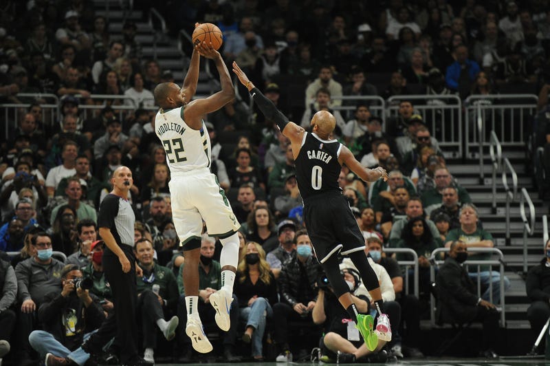 Oct 19, 2021; Milwaukee, Wisconsin, USA; Milwaukee Bucks forward Khris Middleton (22) puts up a shot against Brooklyn Nets guard Jevon Carter (0) in the first half at Fiserv Forum. Mandatory Credit: Michael McLoone-USA TODAY Sports