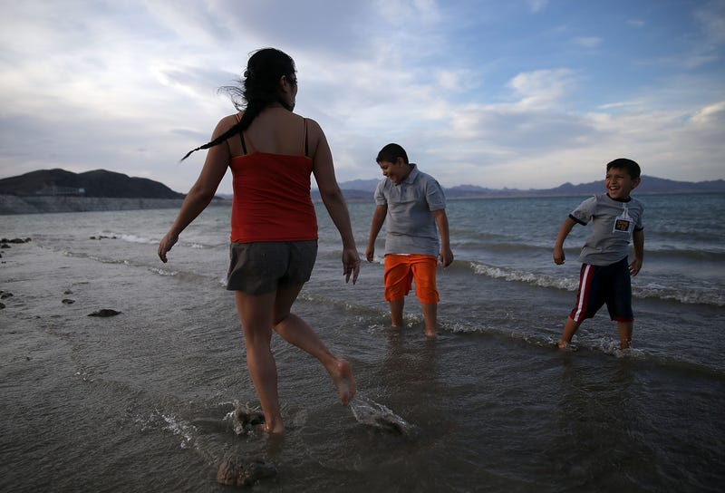 Nancy Veyna (L) stands in the waters of Lake Mead with her sons Kevin Veyna (R) and Luis Veyna (C) at Boulder Beach on May 12, 2015 in Lake Mead National Recreation Area, Nevada
