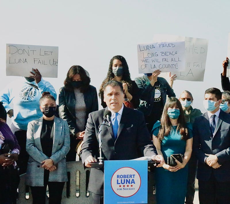 Long Beach Police Chief Robert Luna announced in his candidacy for L.A. County Sheriff. Behind him are protestors against his campaign.