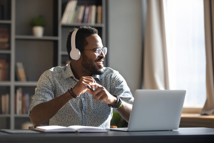 man with headphones on in front of laptop