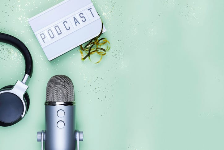 podcast sign, headphones, and a mic