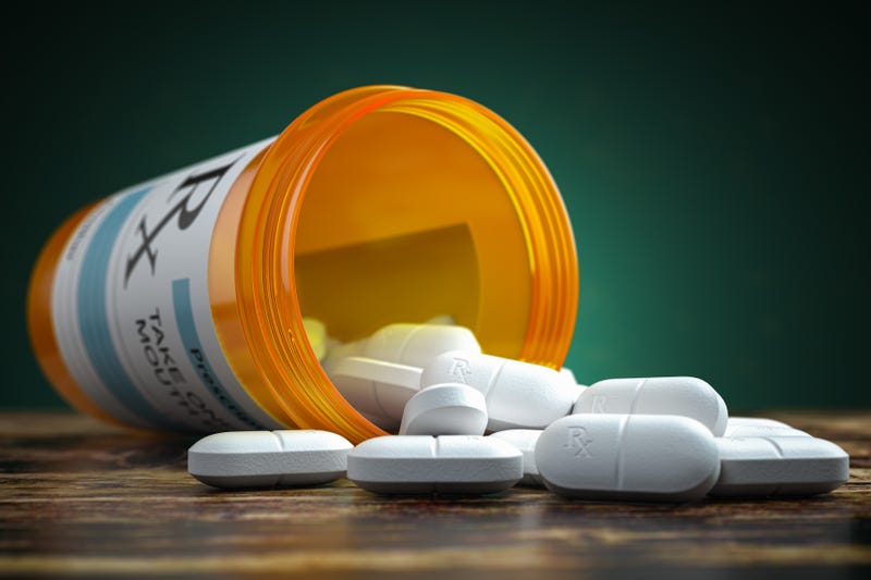 Pills spilling out from yellow container.