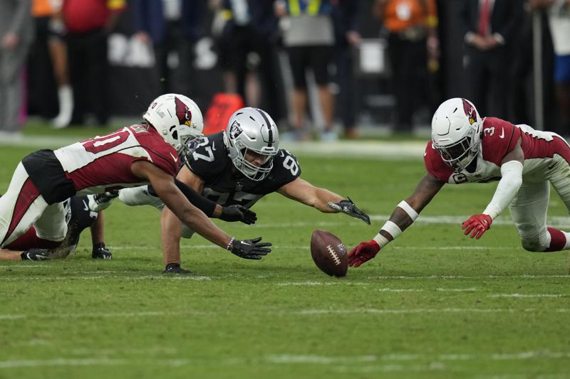 Las Vegas Raiders tight end Foster Moreau (87) recovers a fumble between Arizona Cardinals cornerback Marco Wilson, left, and safety Budda Baker (3) during overtime Sunday, Sept. 18, 2022, in Las Vegas