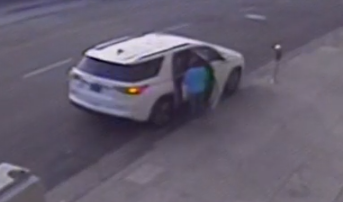 Woman in front of white car during one of the robberies