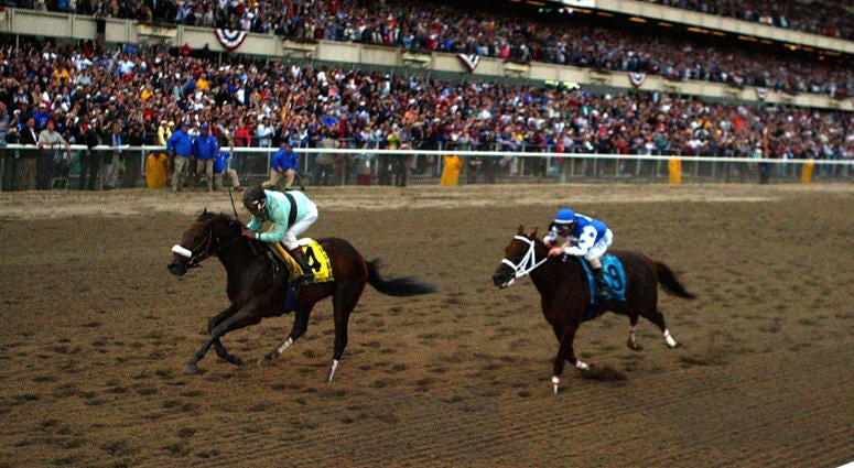 Birdstone (4), riden by Edgar Prado, overtakes Smarty Jones (9), riden by Stewart Elliott, to win the 136th Belmont Stakes on June 5, 2004 at Belmont Park.