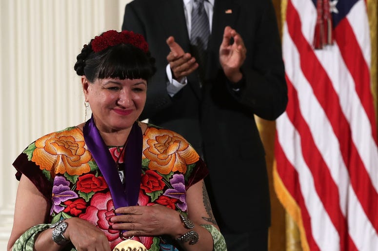 U.S. President Barack Obama (R) presents the National Medal of Arts to author Sandra Cisneros (L) during an East Room ceremony at the White House September 22, 2016 in Washington, DC. President Obama awarded the 2015 National Medal of Arts and the National Humanities Medal to recipients in the annual ceremony.