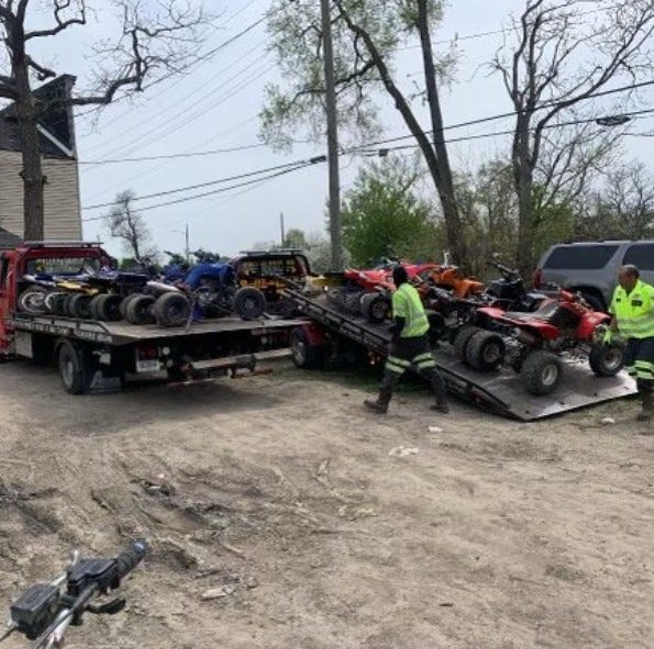 Several ATVs being towed