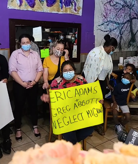 Mutual Aid organizers at La Morada restaurant stand with recently-arrived refugees who were sent to New York as part of Abbott's bussing program.