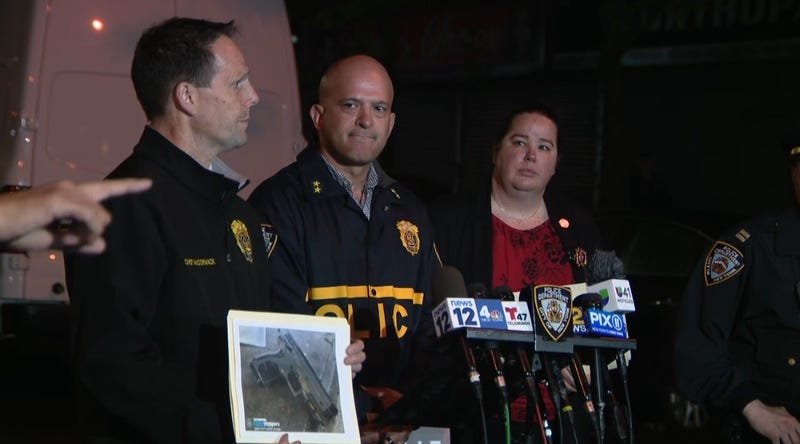 At a press conference, police hold up a picture of the airsoft gun they say officers retrieved after shooting a man to death in the Bronx.