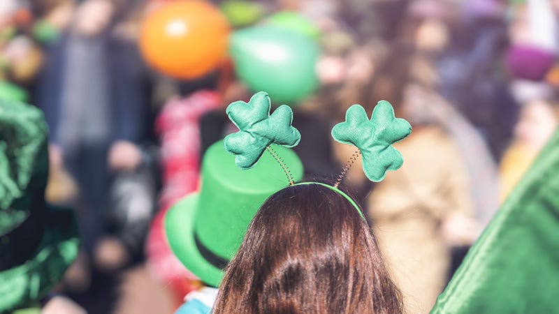 Woman wearing St Patrick's headband watching a parade