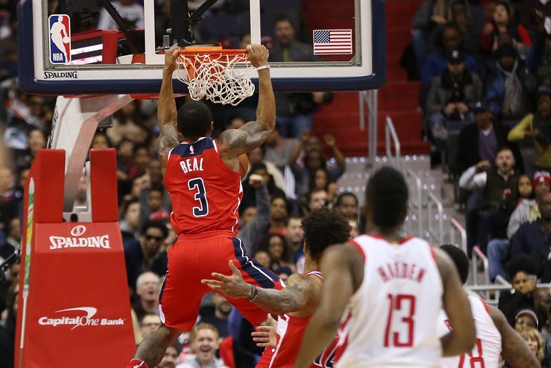 Bradley Beal dunks the ball as James Harden looks on