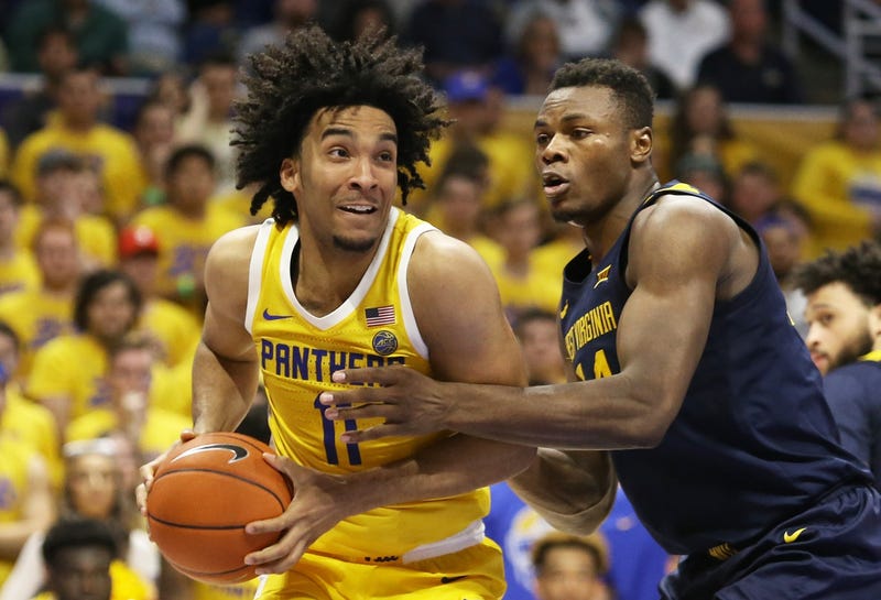 Pittsburgh Panthers guard Justin Champagnie (11) handles the ball against West Virginia Mountaineers forward Oscar Tshiebwe