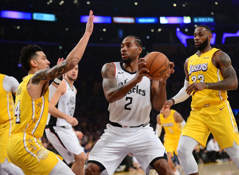 Los Angeles Clippers forward Kawhi Leonard (2) moves to the basket against Los Angeles Lakers guard Danny Green (14) and forward LeBron James (23) during the first half at Staples Center.