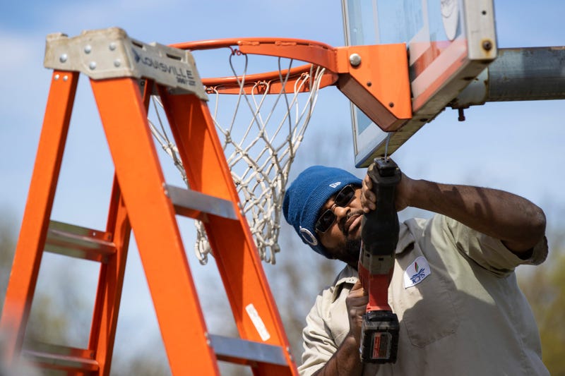 JCPS Crew Member Tyrone Fields takes down a basketball hoop at St. Matthews Elementary School.