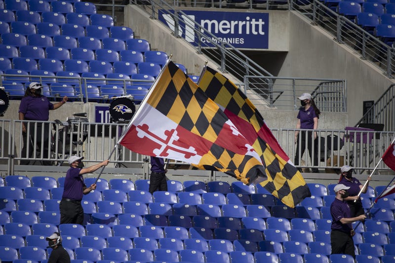 Baltimore Ravens staff wave Maryland flags in empty stands