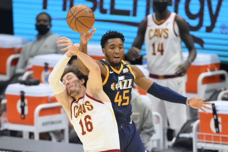 Cleveland Cavaliers forward Cedi Osman (16) and Utah Jazz guard Donovan Mitchell (45) reach for a loose ball in the second quarter at Rocket Mortgage FieldHouse.