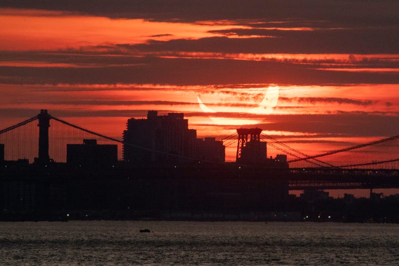 A solar eclipse rises behind the New York City skyline on June 10, 2021