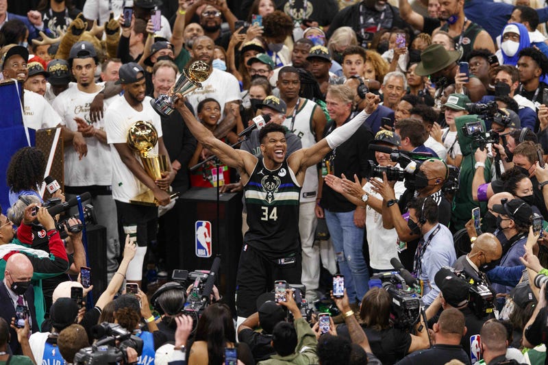 Milwaukee Bucks forward Giannis Antetokounmpo (34) celebrates with the NBA Finals MVP Trophy following the game against the Phoenix Suns following game six of the 2021 NBA Finals at Fiserv Forum.