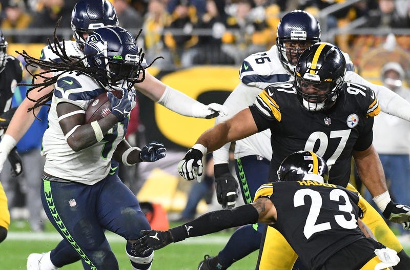 Seattle Seahawks running back Alex Collins (41) is slowed by Pittsburgh Steelers Joe Haden (23) and Cameron Heyward (97)