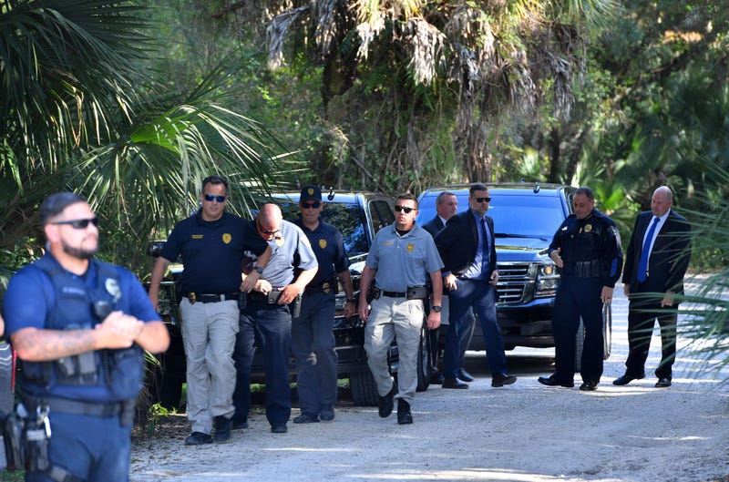 Law enforcement officals gather at the entrance to the Myakkahatchee Creek Environmental Park in North Port, Florida, before holding a press conference on Oct. 21, 2021