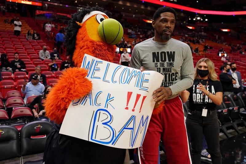 Miami Heat mascot Burnie and forward Udonis Haslem hold up a sign welcoming back center Bam Adebayo