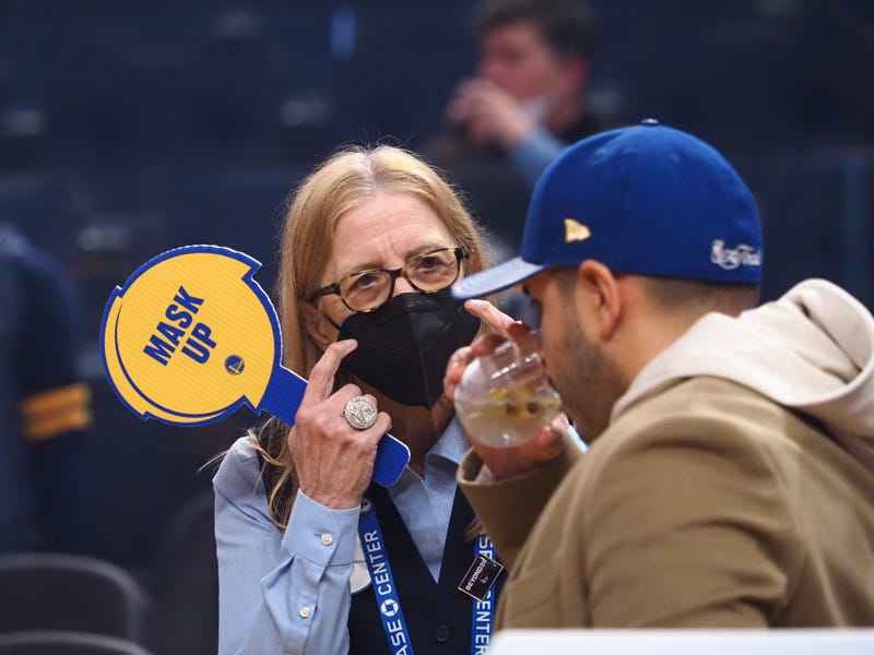 A Chase Center employee asks a fan to put their mask on before the game between the Golden State Warriors and Denver Nuggets at Chase Center.