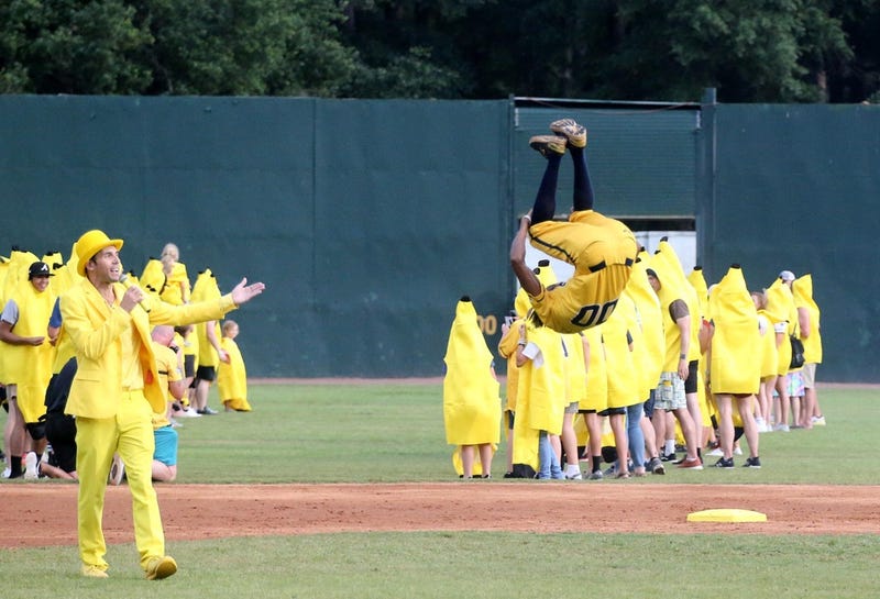 Savannah Bananas dancing first base coach Maceo Harrison flips through the air as team owner Jesse Cole introduces him at Grayson Stadium.