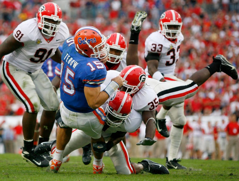 Oct 27, 2007; Jacksonville, FL, USA; Florida Gators quarterback Tim Tebow (15) is tackled by Georgia Bulldogs safety Reshad Jones (9) and linebacker Rennie Curran (35) during the third quarter at Jacksonville Municipal Stadium in Jacksonville, Florida. Georgia defeated Florida 42-30.