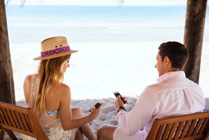 People texting while on vacation at the beach