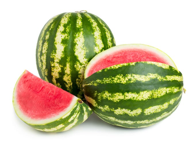 Slice of watermelon in a hand, sunny day, summer concept.