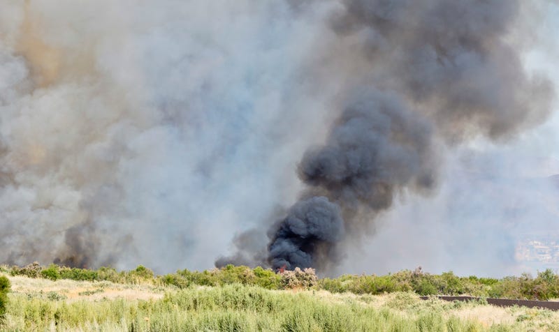 A wildfire burns in a desert area