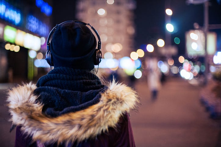 woman in coat wearing headphones