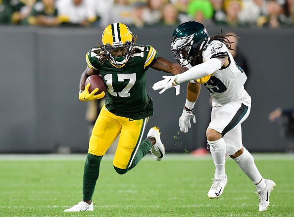 Davante Adams stiff arms and Eagles defensive back.