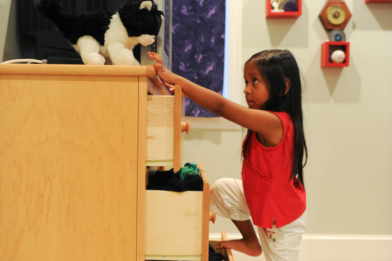 A child begins to climb a dresser