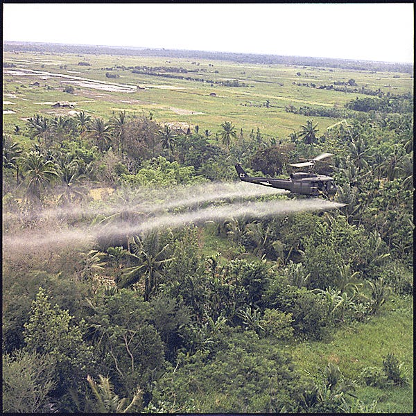 A helicopter sprays herbicide over Vietnam.