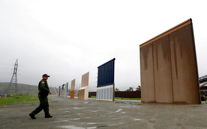 Border Patrol agent Vincent Pirro walks towards prototypes for a border wall in San Diego.