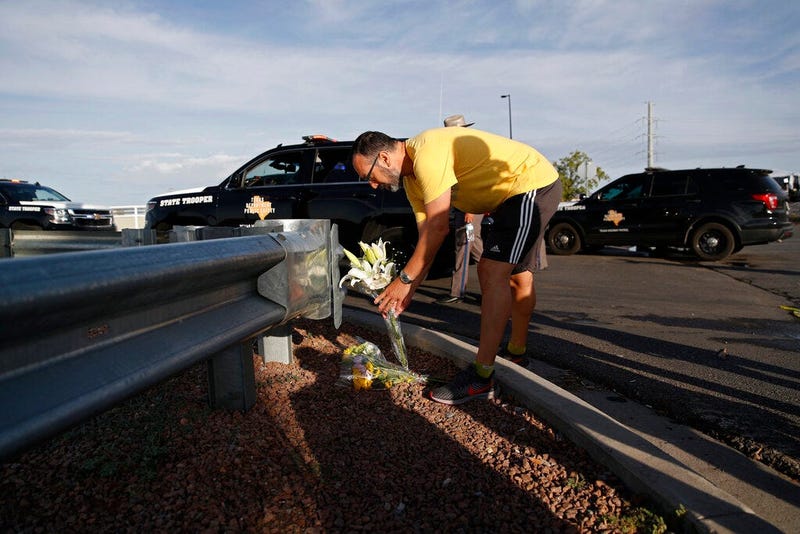 A man leaves flowers near the scene of a mass shooting at a shopping complex Sunday, Aug. 4, 2019, in El Paso, Texas.