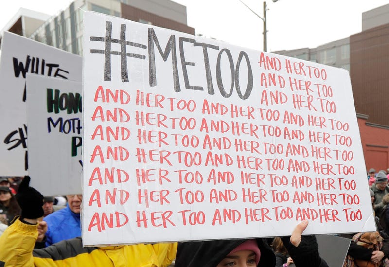 A demonstrator carries a sign with the popular Twitter hashtag #MeToo used by people speaking out against sexual harassment as she takes part in a Women's March in Seattle.