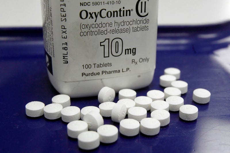 Aa pharmacist in San Francisco poses for photos holding a bottle of OxyContin.