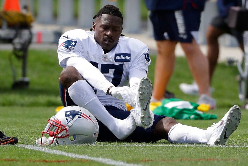 New England Patriots wide receiver Antonio Brown puts on his shoe during an NFL football practice, Wednesday, Sept. 18, 2019, in Foxborough, Mass.