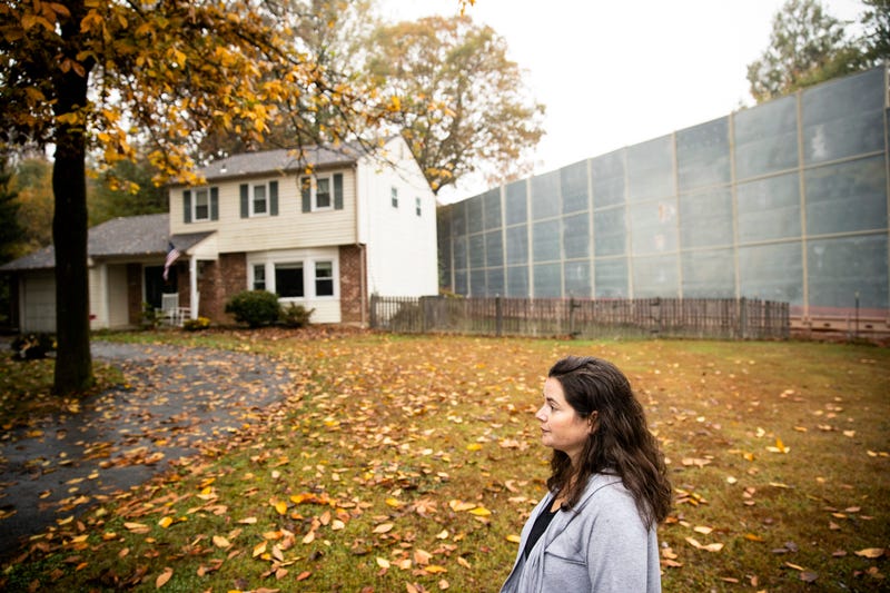 Carrie Gross walks past a construction barrier shielding the Mariner East pipeline near a home during an interview with The Associated Press in Exton, Pa.
