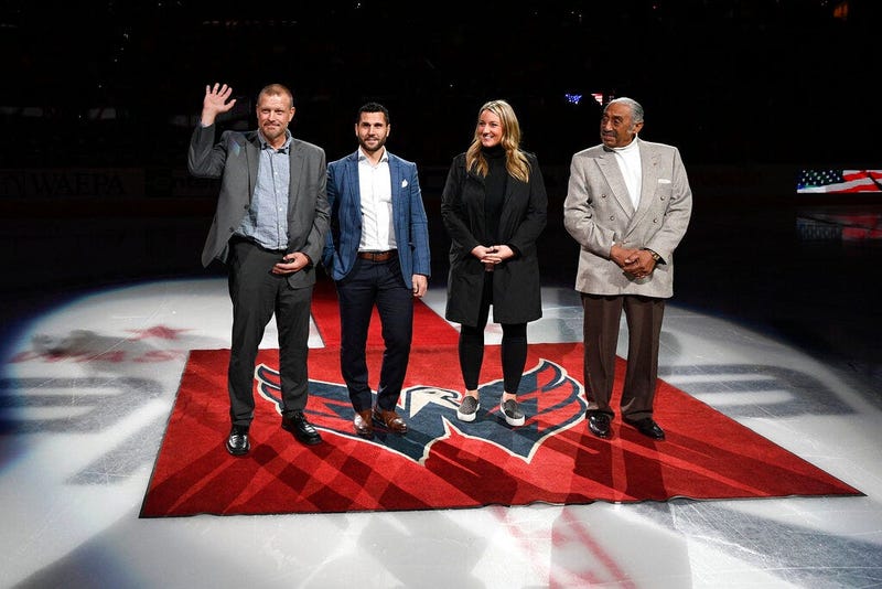 The 2019 U.S. Hockey Hall of Fame class, from left to right, Tim Thomas, Brian Gionta, Krissy Wendell and Neal Henderson stand on the ice before a ceremonial puck drop ahead of an NHL hockey game
