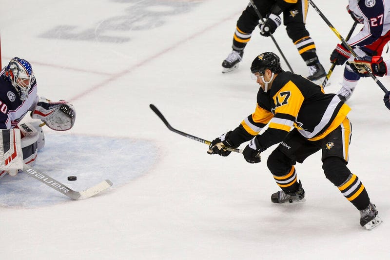 Pittsburgh Penguins' Bryan Rust (17) shoots and scores the game winning goal on Columbus Blue Jackets goaltender Joonas Korpisalo, left, during the overtime period of an NHL hockey game, Thursday, Dec. 12, 2019, in Pittsburgh. Pittsburgh Penguins won 1-0.