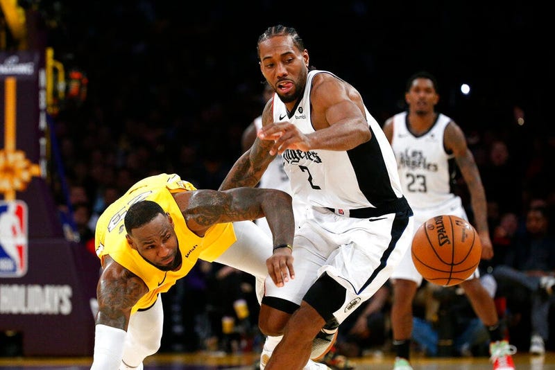 Los Angeles Lakers' LeBron James, left, and Los Angeles Clippers' Kawhi Leonard (2) chase the ball during the second half of an NBA basketball game Wednesday, Dec. 25, 2019, in Los Angeles. The Clippers won 111-106.