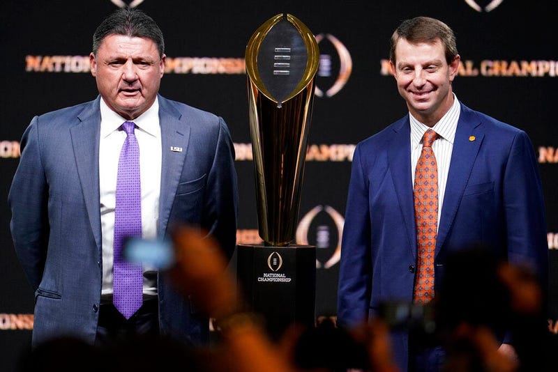 LSU head coach Ed Orgeron, left, and Clemson head coach Dabo Swinney pose with the trophy after a news conference for the NCAA College Football Playoff national championship game Sunday, Jan. 12, 2020, in New Orleans. Clemson is scheduled to play LSU on M
