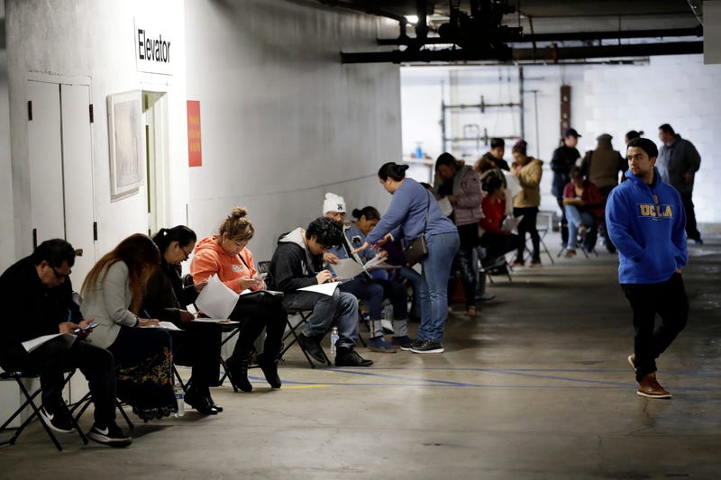Unionized hospitality workers wait in line in a basement garage to apply for unemployment benefits at the Hospitality Training Academy in Los Angeles.