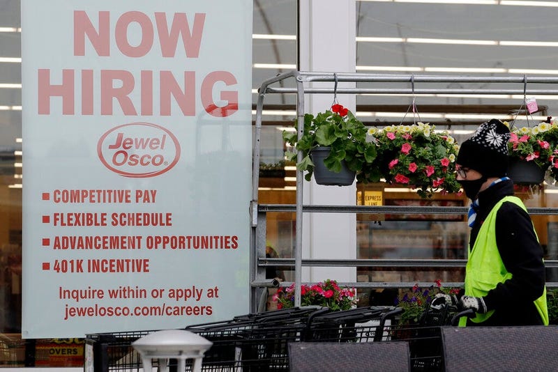 A man pushes carts as a hiring sign shows at a Jewel Osco grocery store in Deerfield, Ill., Thursday, April 23, 2020. Friday, Dec. 4. (AP Photo/Nam Y. Huh)