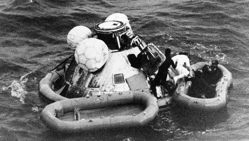 In this Dec. 27, 1968 file photo, divers help recover the Apollo 8 crew from their capsule after splashdown in the Pacific Ocean.